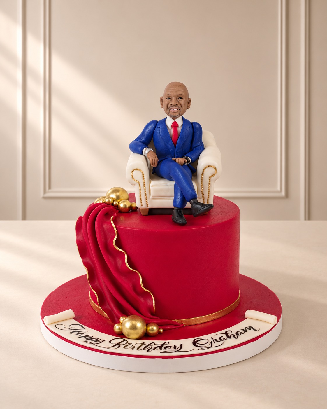 Red Fondant Cake with Modelled Figure on an Armchair